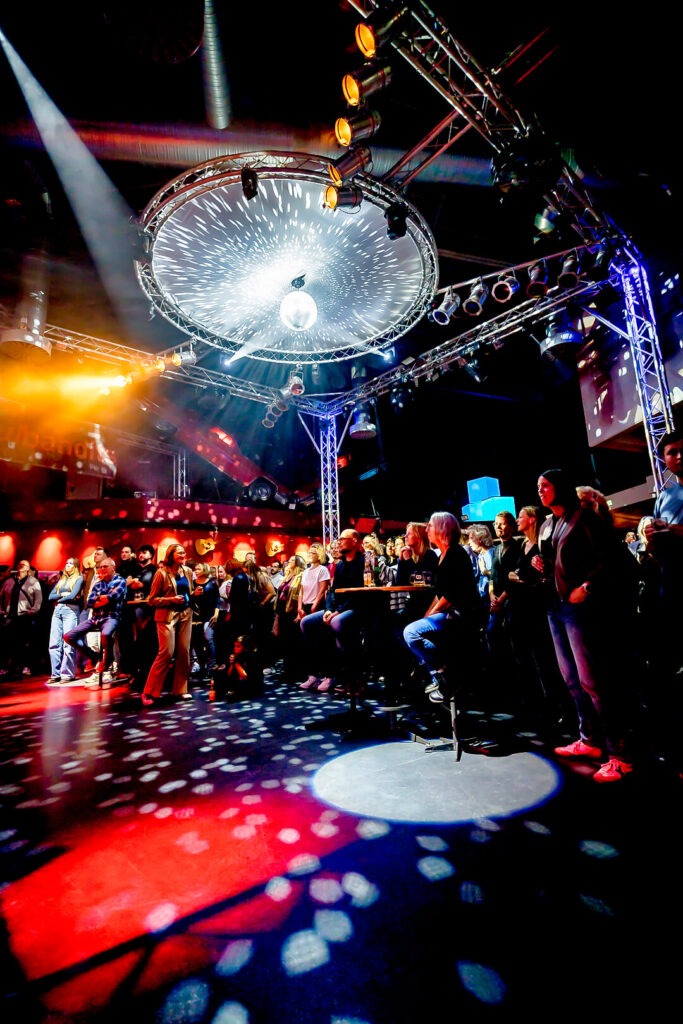 Menschenmenge bei Konzert mit Bühnenbeleuchtung