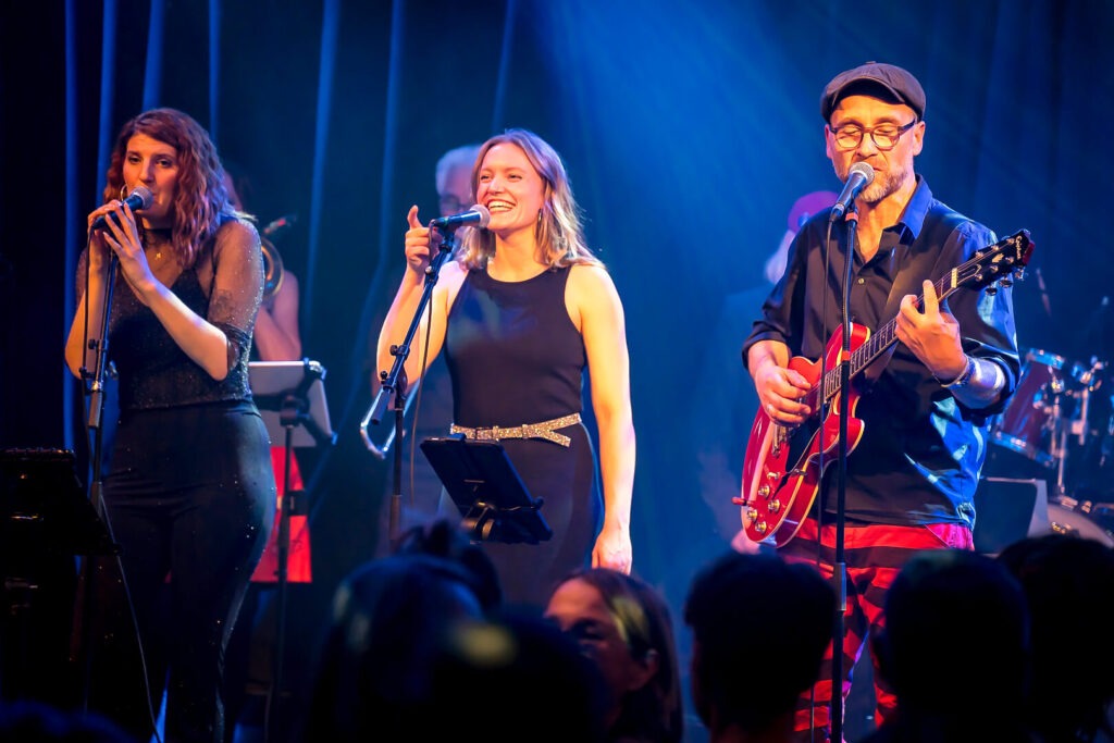 Band spielt Live-Konzert auf einer Bühne.