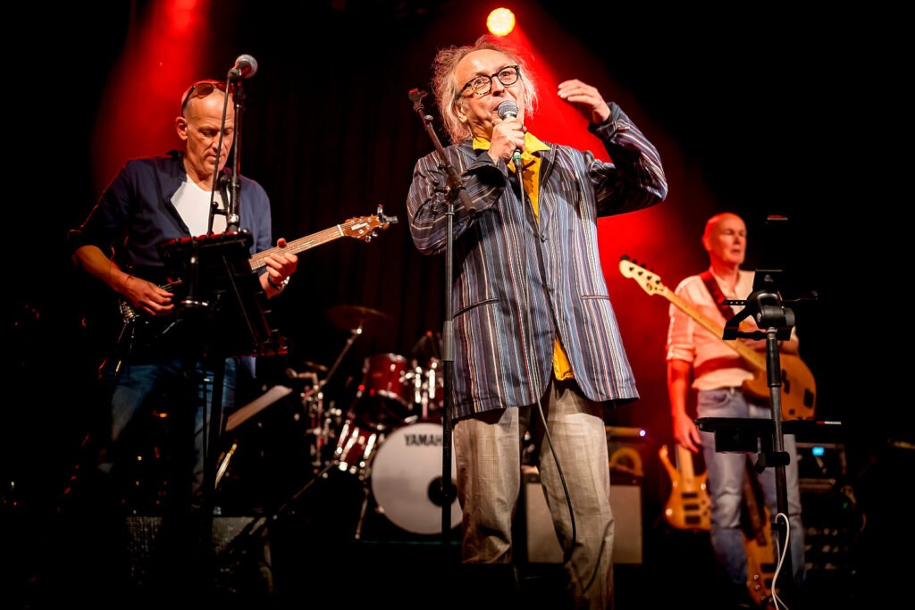Bandauftritt mit Sänger und Gitarristen auf der Bühne.