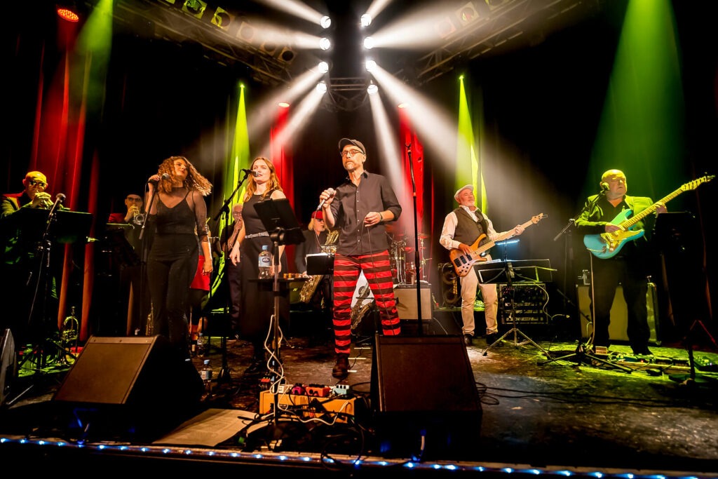 Band spielt live auf der Bühne mit Beleuchtung.