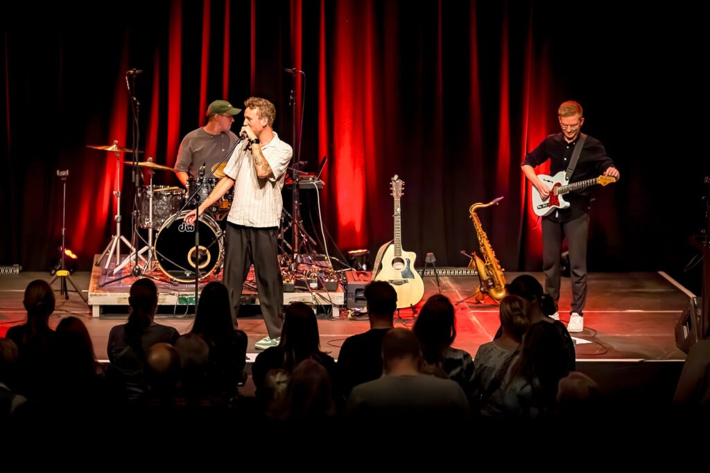 Band spielt auf Bühne vor Publikum.
