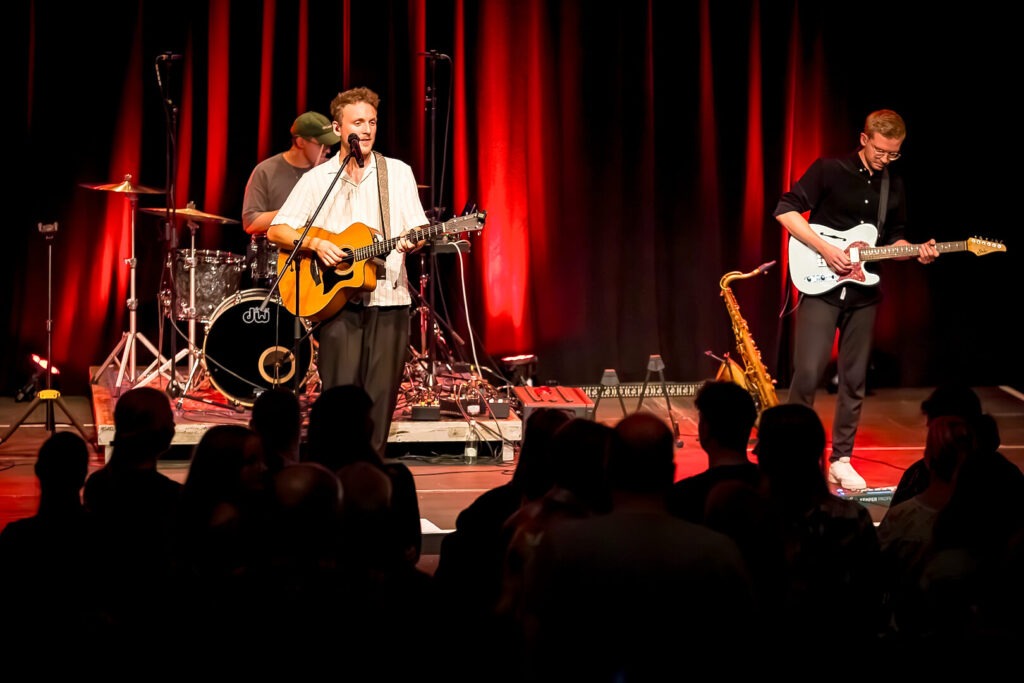 Band spielt Live-Konzert auf Bühne mit Publikum