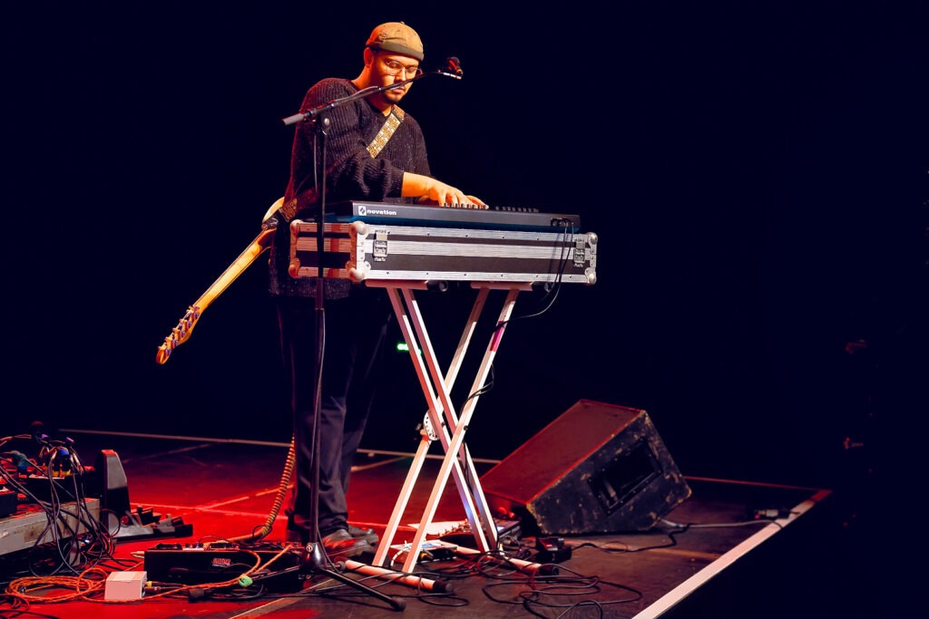 Musiker spielt auf einem Keyboard auf der Bühne.