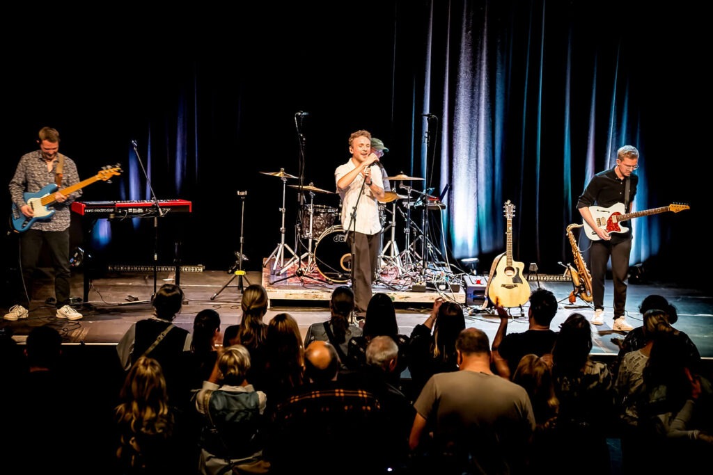Band spielt auf Bühne vor Publikum