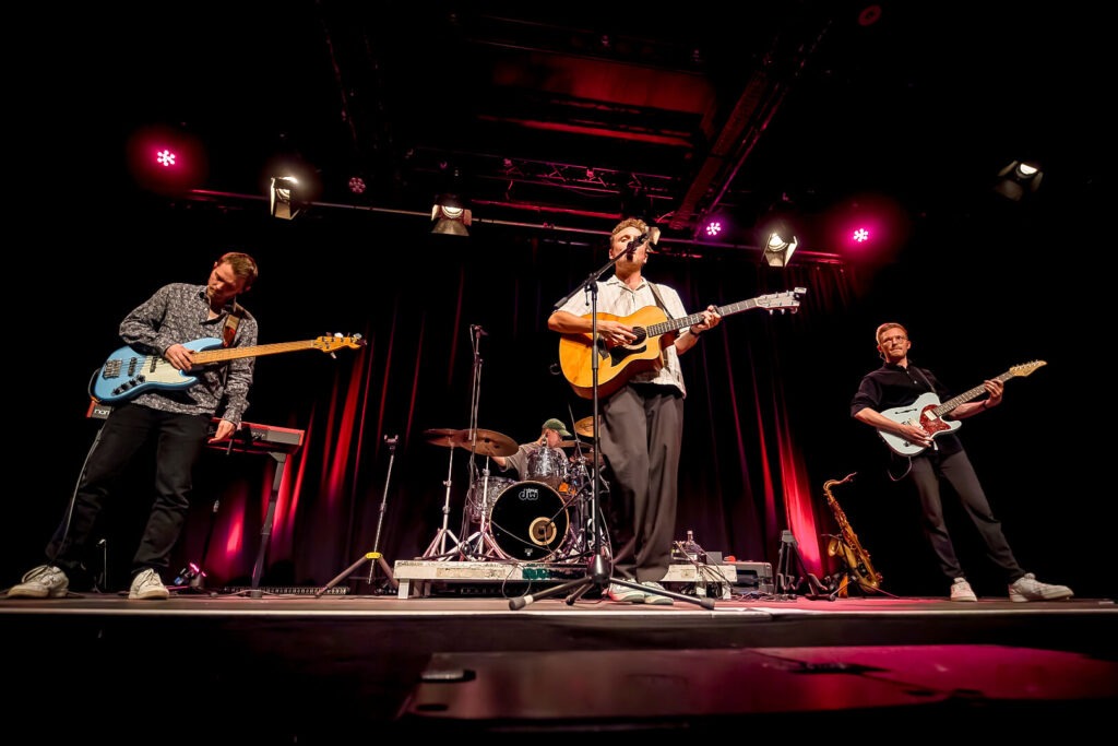 Band spielt Live-Musik auf einer Bühne.