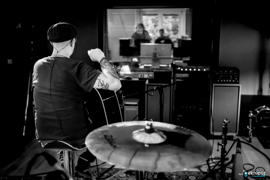 Musiker im Aufnahmestudio mit Gitarre.