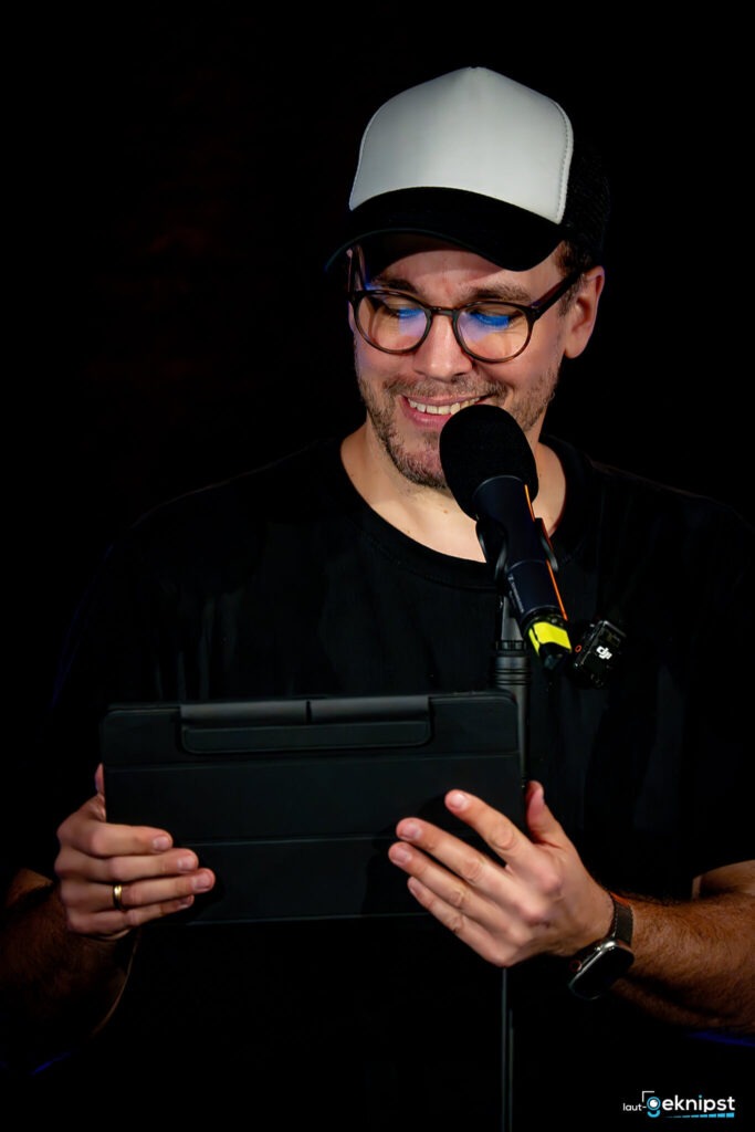 Person mit Tablet und Mikrofon auf der Bühne