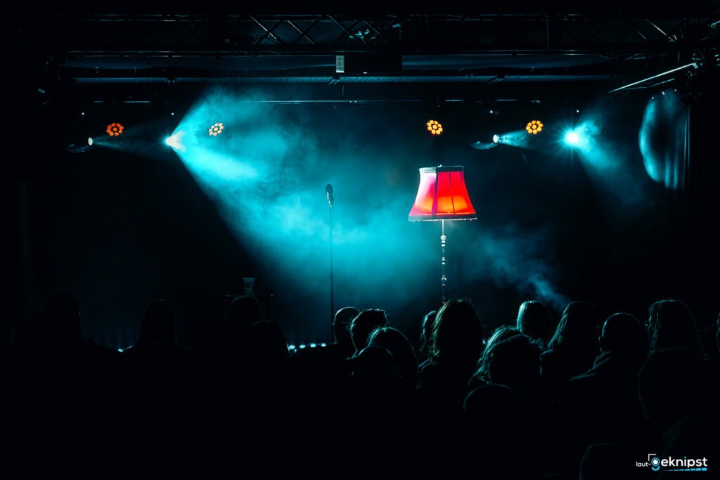 Bühne mit Mikrofon und roter Lampe vor Publikum