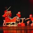 Kinder in Weihnachtskostümen mit Schlitten improvisieren