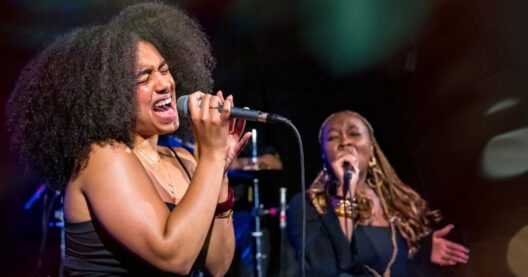 Zwei Frauen singen leidenschaftlich auf der Bühne.