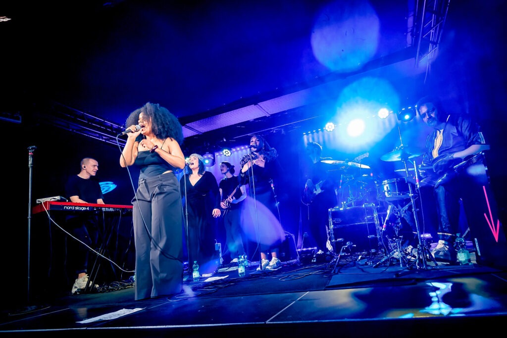 Band auf der Bühne mit Sängerin und Instrumenten