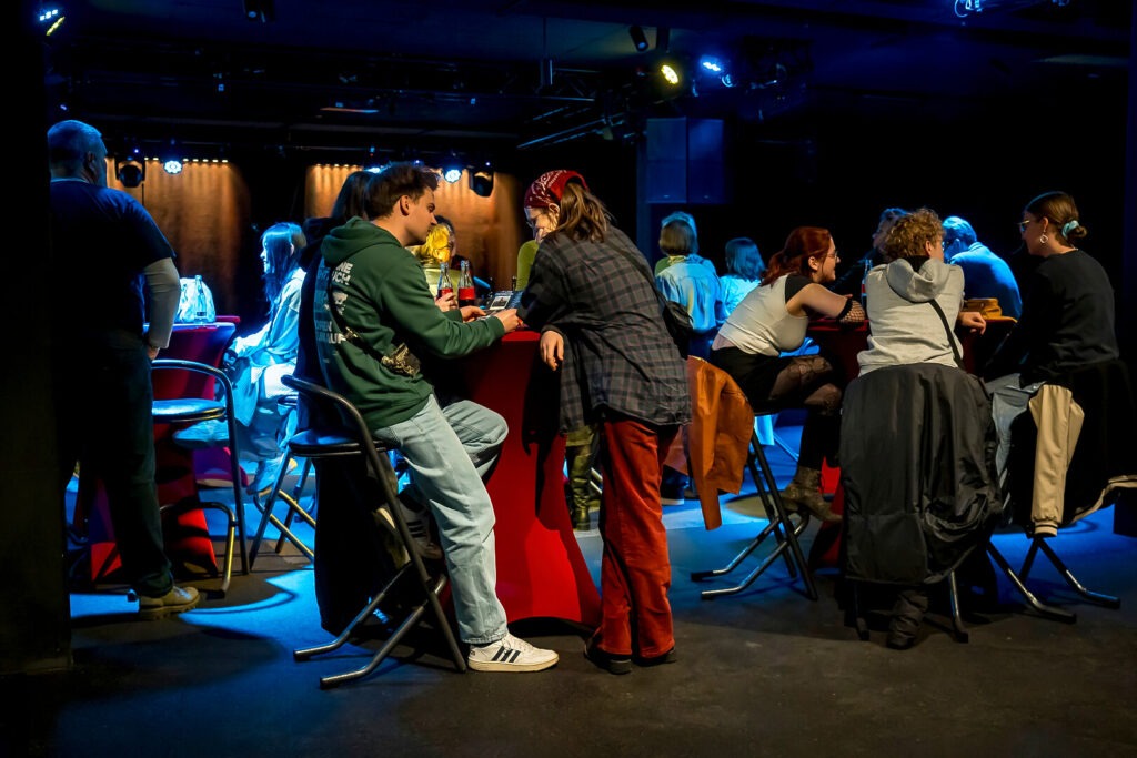 Menschen unterhalten sich an einem Tisch in einer Bar.