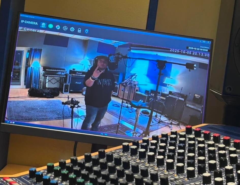 Mann im Tonstudio auf Überwachungsmonitor.