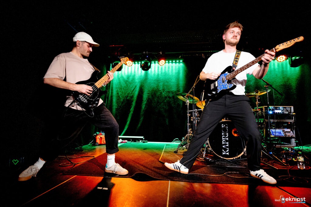 Zwei Musiker spielen E-Gitarren auf der Bühne.
