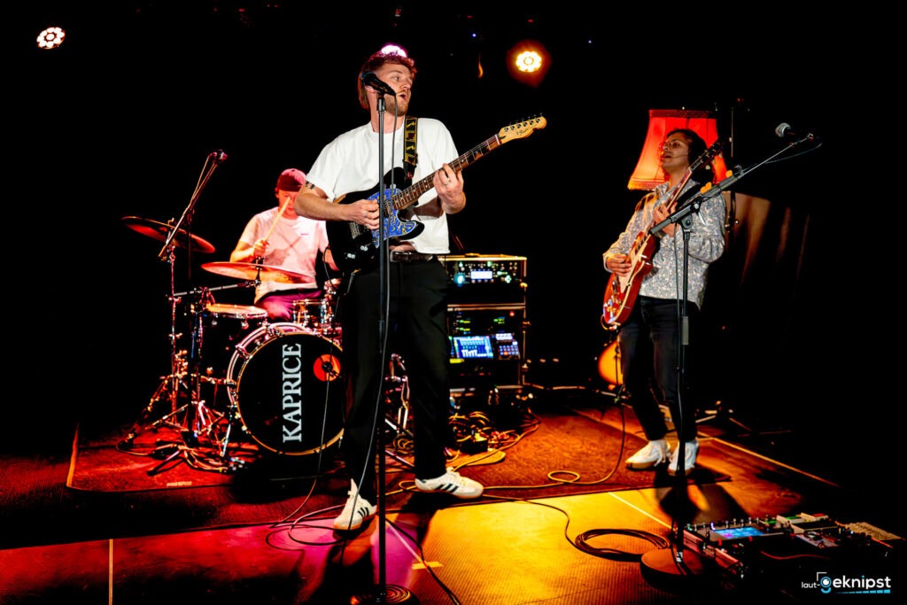 Band spielt live auf der Bühne mit Instrumenten.