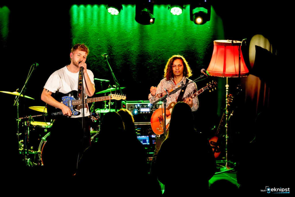 Band spielt Livemusik auf der Bühne mit Lampenbeleuchtung.