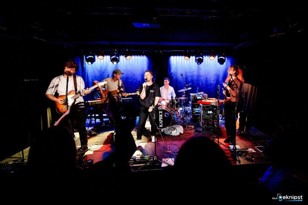 Live-Band-Auftritt auf einer Bühne mit Publikum.