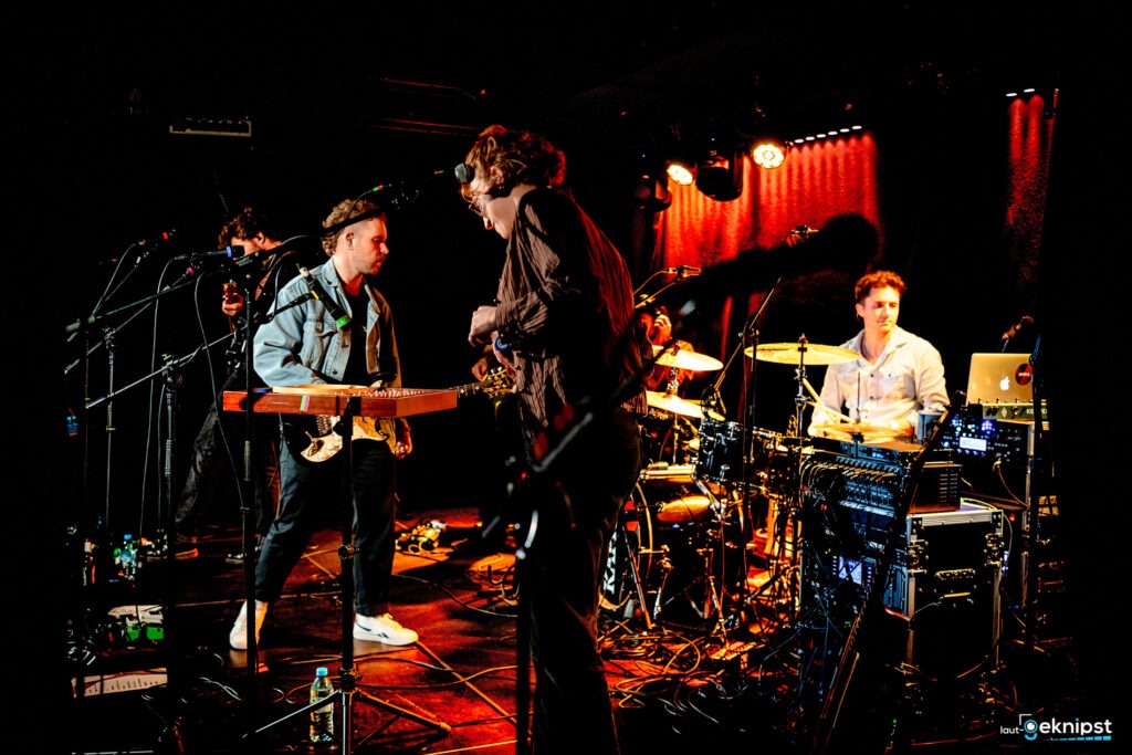 Band spielt live auf Bühne mit Schlagzeug.