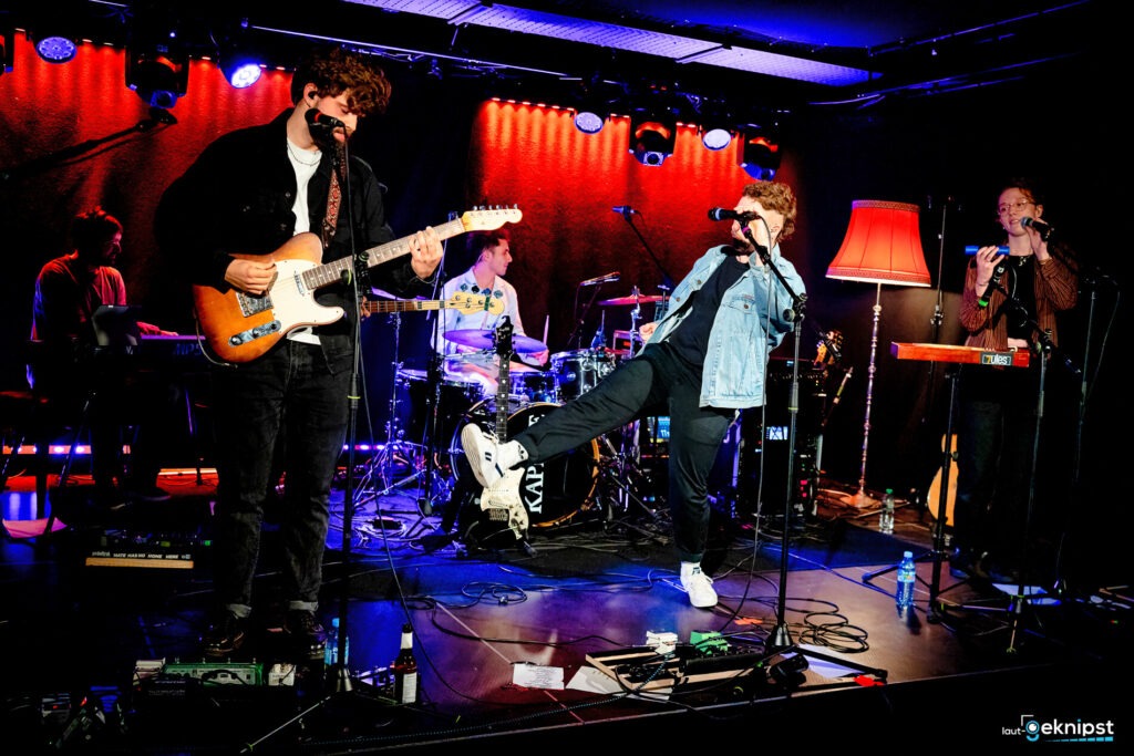 Band performt live auf Bühne mit Instrumenten